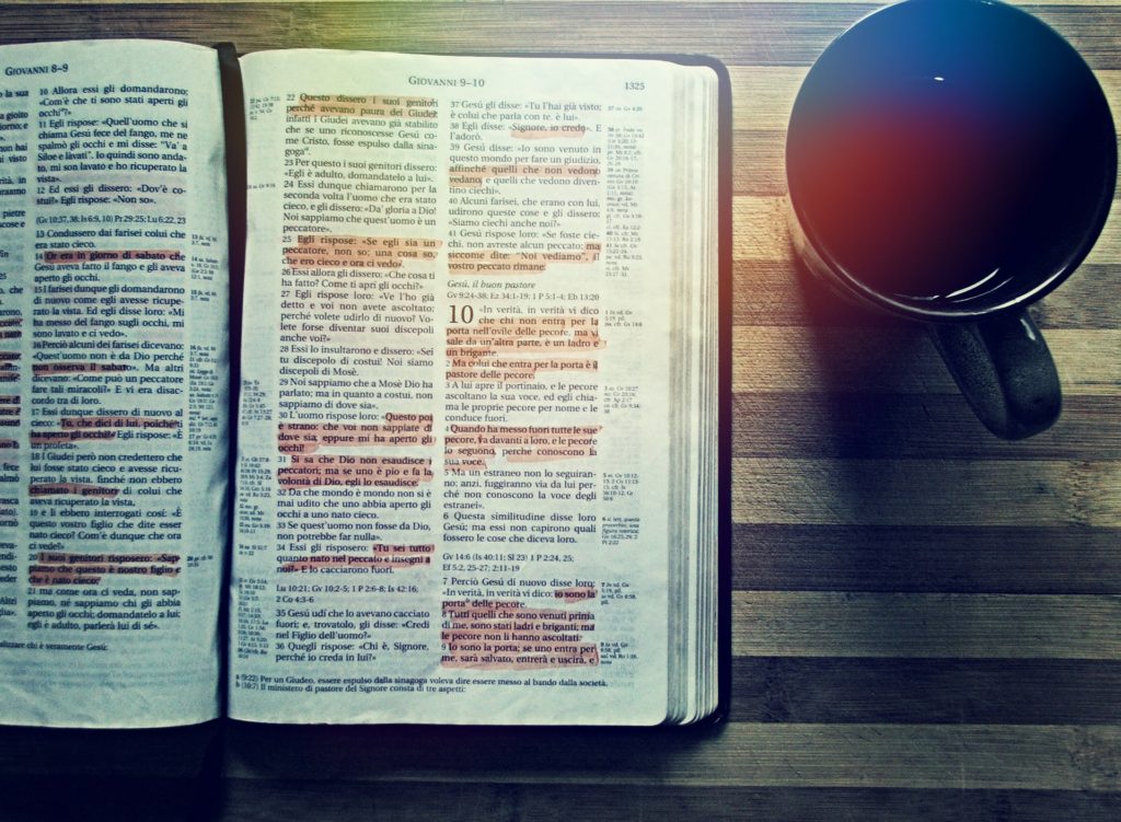 A Bible next to a cup of coffee