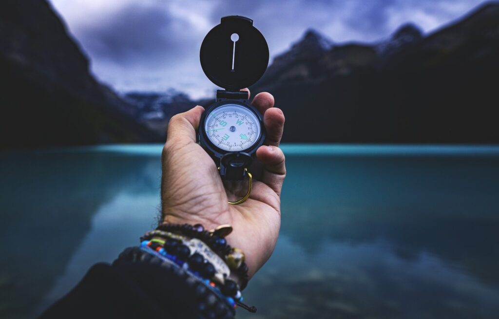 Holding a compass at the lake
